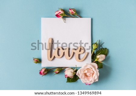 Flowers composition. Postcard concept. Greeting card made of pink rose flowers on blue background. Flat lay, top view, copy space, soft focus. Minimalism.