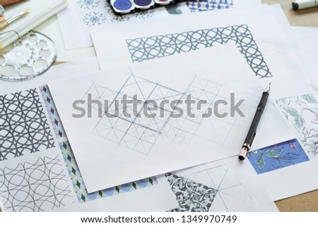 Designer designing drawing sketch pattern geometric flower seamless wallpaper fabric textile fashion industry. artistic design studio.
