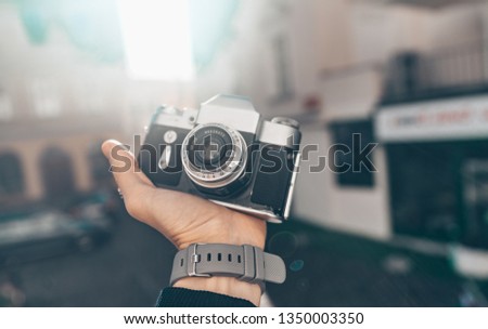 Men's hands with a camera in sunlight