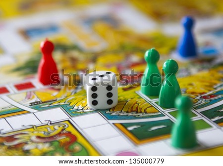 Colorful play figures with dice on board Royalty-Free Stock Photo #135000779