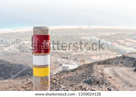 Post on the Fuerteventura mountains informing hikers about the trail. Sign says: Natural trail. Natural trails of Fuerteventura.