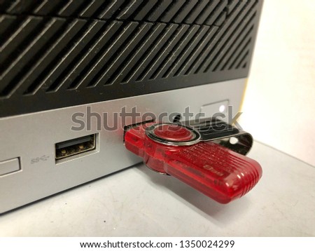 closed up shot of a red Thumbdrive inserted into a USB port of a CPU