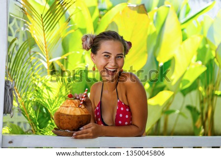 beautiful female drinking coconut through a straw, tropical vacation