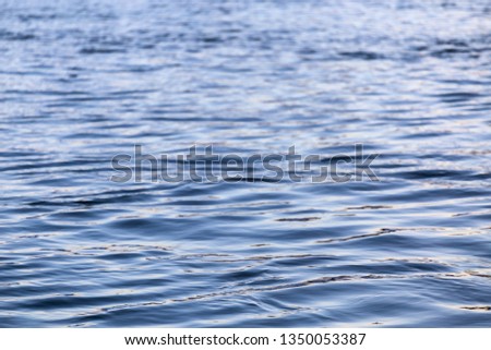 abstract water surface closeup with small plain ripples and selective focus