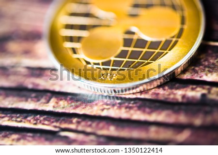 Golden ripple coin. Crypto XRP Coin on dark wood background.  Close-up, macro shot.New Virtual Money 
