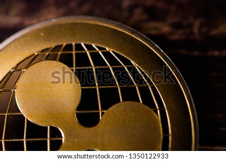 Golden ripple coin. Crypto XRP Coin on dark wood background . Close-up, macro shot.New Virtual Money 