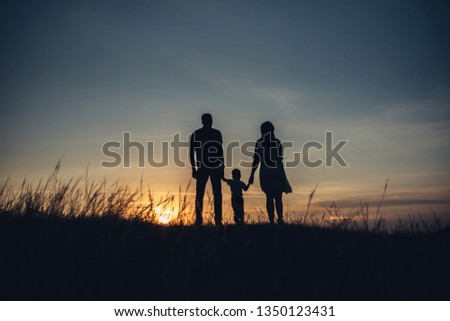 Happy family together, parents with their little baby at sunset.