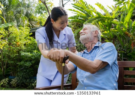 senior man happiness and smiling nurse, takes care and discussion and cheer in the garden at nursing home