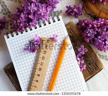 Flowers of lilac with blank notebook, pencil and ruler. Romantic spring picture