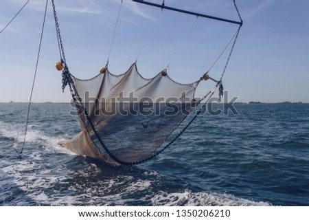 straightened trawler net is going down to sea bottom Royalty-Free Stock Photo #1350206210