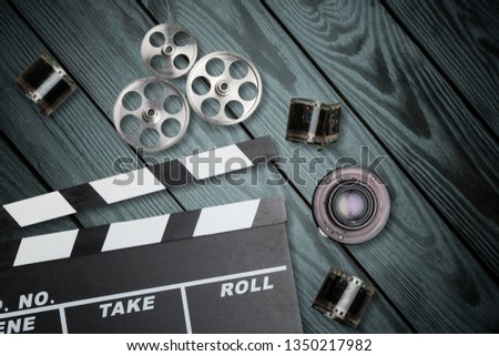 vintage classic clapperboard and lenses on brown wooden table