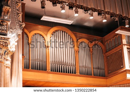 Musical organ with gray tubes and beautiful columns from the side. Bottom view