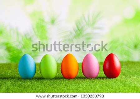 Happy Easter - Colored eggs on grass and green abstract background
