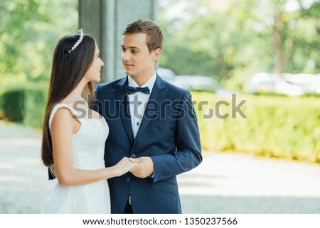 the bride and groom hold each other's hands near the castle and smile