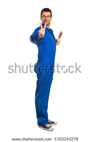 A full-length shot of a Painter man smiling and showing victory sign on isolated white background