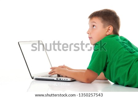 casual teenager in bright green t-shirt with laptop over white background. Use or harm of computer games, children's leisure and schooling.