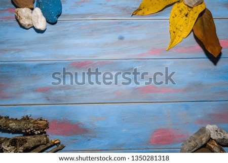 blue toned wooden background with summer objects in the corners with space to edit text