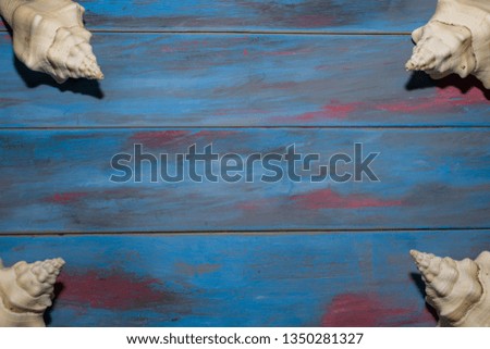 blue toned wooden background with conches in the corners with space to edit text