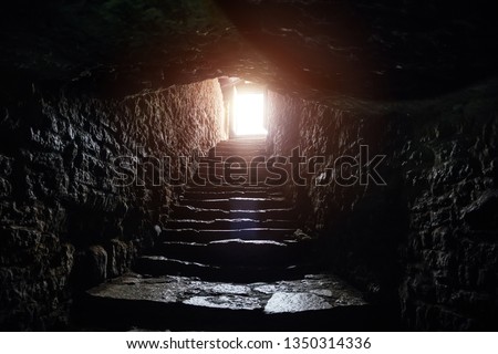 Underground passage under old medieval fortress. Old stone stairs to exit of tunnel. Royalty-Free Stock Photo #1350314336