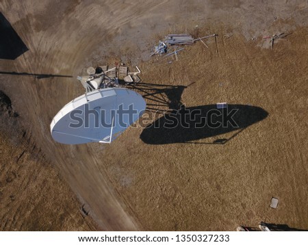 Aerial drone image of an array of large satellite dishes or radio telescopes pointed skyward.