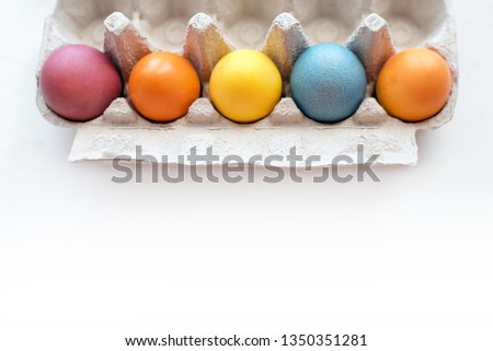 Easter vibes. Top view of colored Easter eggs in paper container. Copyspace for text