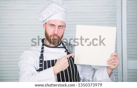 Improve cooking skill. Ultimate cooking guide for beginners. Book family recipes copy space. According to recipe. Man bearded chef author of book. Chef recommend book. Culinary recipes book concept.