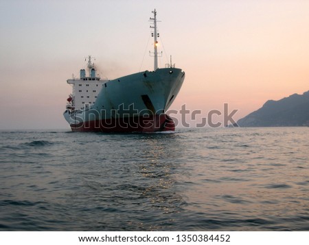a ship enters the port at nightfall Royalty-Free Stock Photo #1350384452
