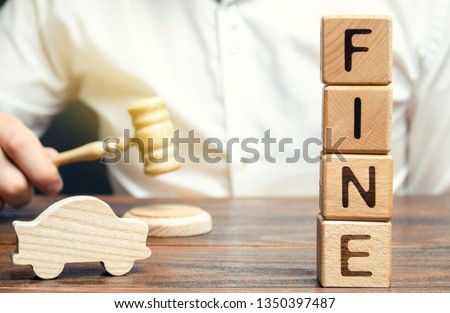 Wooden blocks with the word Fine, wooden car and judge. Violation of traffic laws. Penalty as a punishment for a crime and offense. Financial punishment. Fraud. Fines can also be used as a form of tax