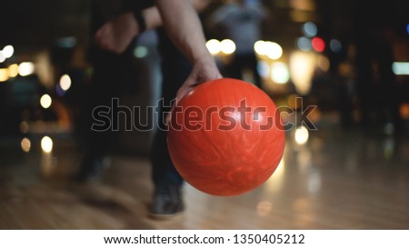 Man is pushing a bowling ball.