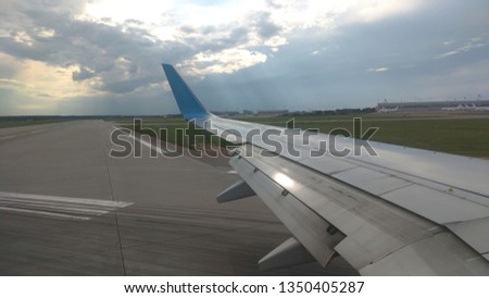 Airplane wing view out of the window on the cloudy sky The Earth background. Holiday vacation background. Wing of airplane flying above the clouds in the sky. Landing airplane, Moscow, Russia.