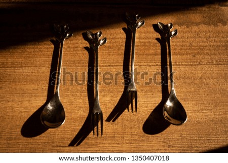 Forks and silver spoons on a wooden table.
