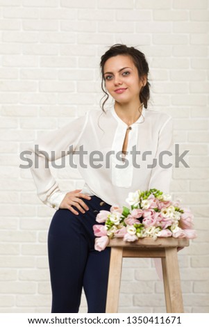 portrait of a beautiful brunette woman with a bouquet of tulips flowers
