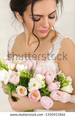 Portrait of beautiful bride with wedding bouquet of pink tulips