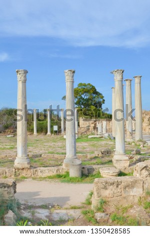 Stunning ruins of ancient Greek city Salamis located in todays Northern Cyprus. The white pillars were part of Salamis Gymnasium. Captured on vertical picture with blue sky above. 