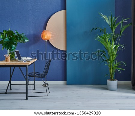 Modern dark blue stone wall, textured wall, blue decorative wall, chair vase of plant and table interior concept. Home wall background. laptop and technology interior room.