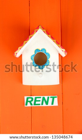 Decorative nesting box and sign on color background