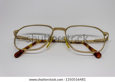 old glasses closeup with gold frame. product photo shoot with white background.