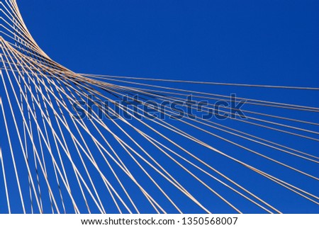 steel cables form lines lines that curve in harmony and pass from a center point and extending radially in all directions Royalty-Free Stock Photo #1350568007