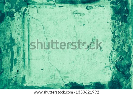 The texture of the old stucco wall with scratches, cracks, dust, crevices, roughness. Can be used as a poster or background for design.  Concrete green frame.