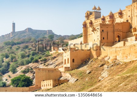 Beautiful view of the Amer Fort and Palace (Amber Fort) on blue sky background in Jaipur, Rajasthan, India. The Jaigarh Fort is visible on Aravalli Hill. Rajput military hill architecture.