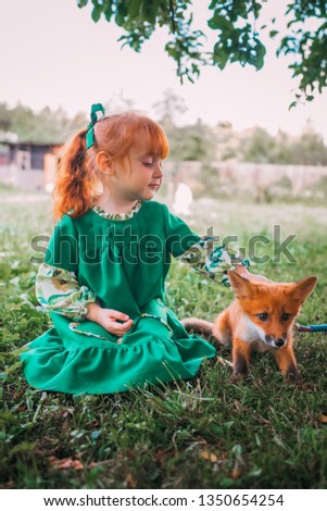the little red girl in a green dress with a fox