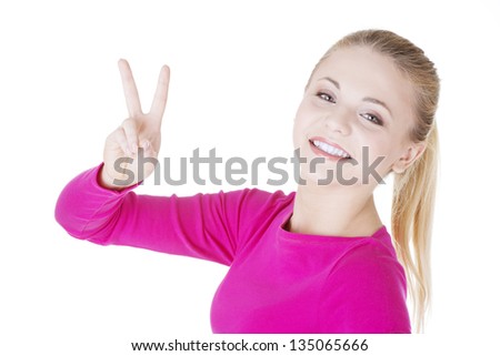 Happy young teenager girl showing victory sign ,isolated on white background