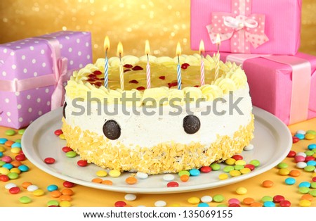 Happy birthday cake and gifts, on yellow background