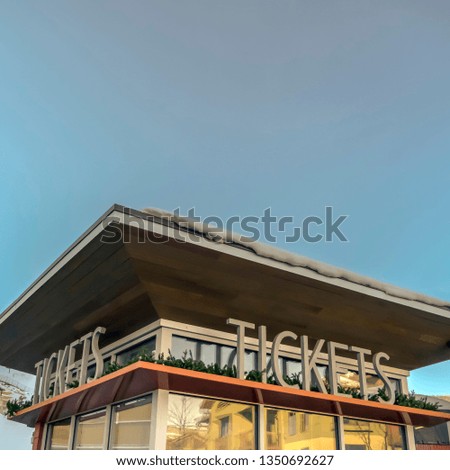 Ticket office with snowy roof against blue sky