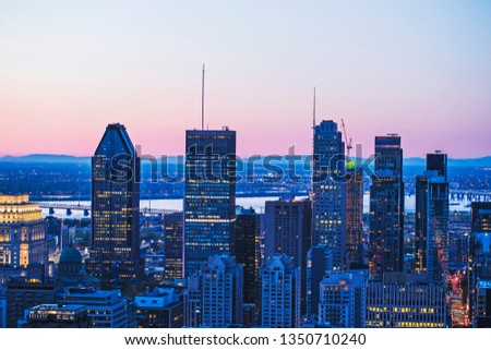 Beautiful red and blue sky and sunrise light over Montreal city in the morning time. Amazing view from Mont-Royal with modern architecture. Montreal downtown skyline and business buildings. 
