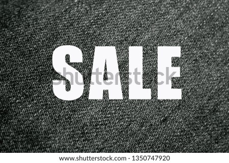 Word sale on black jeans background