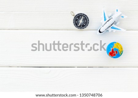 SOS Save the planet concept with the earth, plane and compass on white wooden background flat lay space for text