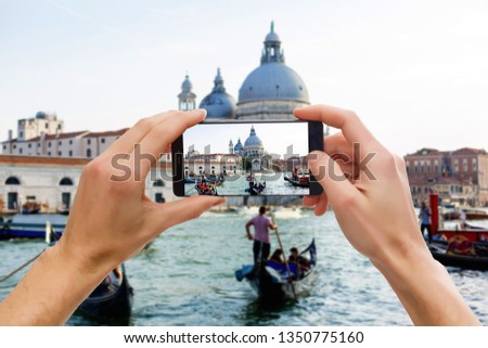 Taking pictures on mobile smart phone in Gondola on Canal Grande with Classic old house in the background, Venice, Italy