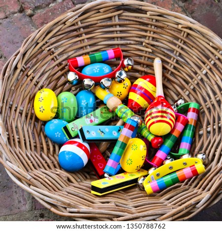 A basket filled with colorful musical percussion instruments. Music and childhood concept image. 