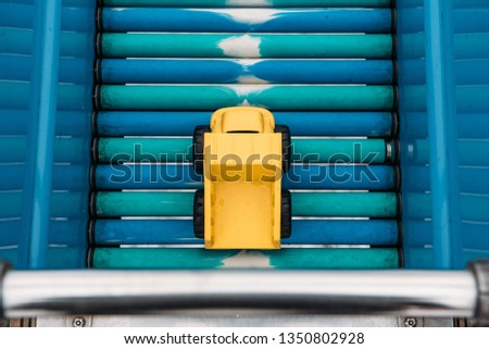Yellow Toy Dump Truck on a Slide Outside